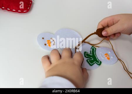 La mano del bambino fa pupazzo di neve per il biglietto d'auguri di natale. Concetto di hobby. Fatto a mano. Foto Stock