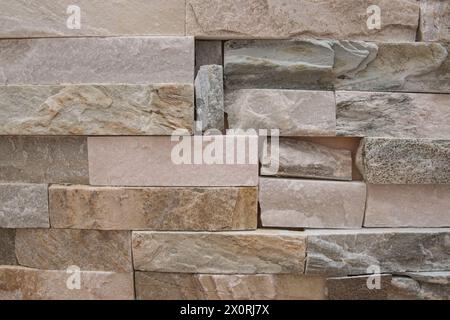 Bella parete in pietra strutturale beige dell'antico edificio è costituito da piccoli mattoni. Foto Stock