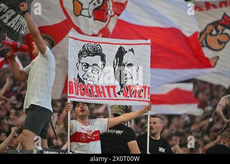 Stoccarda, Germania. 13 aprile 2024. Calcio: Bundesliga, VfB Stuttgart - Eintracht Frankfurt, Matchday 29, MHPArena. I tifosi di Stoccarda reggono uno striscione con slogan contro la direzione del club. Uno dice: "Dimettiti ora!". Credito: Jan-Philipp Strobel/dpa - NOTA IMPORTANTE: in conformità con i regolamenti della DFL German Football League e della DFB German Football Association, è vietato utilizzare o far utilizzare fotografie scattate nello stadio e/o della partita sotto forma di immagini sequenziali e/o serie di foto video./dpa/Alamy Live News Foto Stock