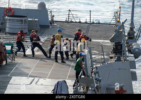 240116-N-HE057-1251 RED SEA (16 gennaio 2024) i marinai, assegnati al cacciatorpediniere missilistico guidato classe Arleigh Burke USS Mason (DDG 87), hanno sollevato la linea di carburante durante un rifornimento in mare nel Mar Rosso, 16 gennaio. Mason è schierato nella 5th Fleet area of Operations per sostenere la sicurezza marittima e la stabilità nella regione del Medio Oriente. (Foto ufficiale della Marina degli Stati Uniti) Foto Stock