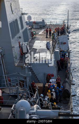 240116-N-HE057-1134 RED SEA (16 gennaio 2024) i marinai, assegnati al cacciatorpediniere missilistico guidato classe Arleigh Burke USS Mason (DDG 87), partecipano a un rifornimento in mare nel Mar Rosso, 16 gennaio. Mason è schierato nella 5th Fleet area of Operations per sostenere la sicurezza marittima e la stabilità nella regione del Medio Oriente. (Foto ufficiale della Marina degli Stati Uniti) Foto Stock