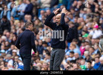 (240414) -- MANCHESTER, 14 aprile 2024 (Xinhua) -- il manager del Manchester City Pep Guardiola reagisce durante la partita di Premier League inglese tra Manchester City e Luton Town a Manchester, Regno Unito, 13 aprile 2024. (XINHUA) SOLO PER USO EDITORIALE. NON IN VENDITA PER CAMPAGNE PUBBLICITARIE O DI MARKETING. DIVIETO DI UTILIZZO CON AUDIO, VIDEO, DATI, ELENCHI DI INCONTRI, LOGHI CLUB/LEAGUE O SERVIZI "LIVE" NON AUTORIZZATI. UTILIZZO ONLINE IN-MATCH LIMITATO A 45 IMMAGINI, SENZA EMULAZIONE VIDEO. NON È CONSENTITO L'USO IN SCOMMESSE, GIOCHI O PUBBLICAZIONI PER SINGOLI CLUB/CAMPIONATO/GIOCATORI. Foto Stock