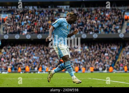 (240414) -- MANCHESTER, 14 aprile 2024 (Xinhua) -- Jeremy Doku del Manchester City celebra i punteggi durante la partita di Premier League inglese tra Manchester City e Luton Town a Manchester, Regno Unito, 13 aprile 2024. (XINHUA) SOLO PER USO EDITORIALE. NON IN VENDITA PER CAMPAGNE PUBBLICITARIE O DI MARKETING. DIVIETO DI UTILIZZO CON AUDIO, VIDEO, DATI, ELENCHI DI INCONTRI, LOGHI CLUB/LEAGUE O SERVIZI "LIVE" NON AUTORIZZATI. UTILIZZO ONLINE IN-MATCH LIMITATO A 45 IMMAGINI, SENZA EMULAZIONE VIDEO. NON È CONSENTITO L'USO IN SCOMMESSE, GIOCHI O PUBBLICAZIONI PER SINGOLI CLUB/CAMPIONATO/GIOCATORI. Foto Stock