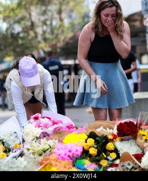 (240414) -- SYDNEY, 14 aprile 2024 (Xinhua) -- Una donna reagisce mentre lascia fiori fuori dal Westfield Shopping Centre a Bondi Junction a Sydney, Australia, 14 aprile 2024. La polizia australiana di domenica ha identificato l'autore di un centro commerciale di Sydney pugnalando che ha ucciso sei persone, dicendo che nessuna intelligence avrebbe suggerito che l'attacco fosse guidato dall'ideologia. L'autore dell'attacco del sabato pomeriggio al Westfield Shopping Centre di Bondi Junction è Joel Cauchi di 40 anni del Queensland, New South Wales (NSW), il Commissario assistente di polizia Anthony Cooke, ha detto ai giornalisti. (Xinhua/ma P Foto Stock