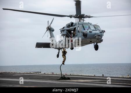 240413-N-YF131-1082 PACIFIC OCEAN (13 aprile 2024) Explosive Ordnance Disposal 1st Class Evan Bruce, da Coconut Creek, Flag., respinge da un MH-60S S. Foto Stock