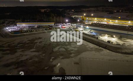 Fotografia con droni di magazzini logistici e camion parcheggiati durante la notte nuvolosa d'inverno Foto Stock