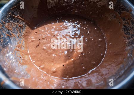 Primo piano del mix di cupcake al cioccolato all'interno del recipiente di miscelazione in metallo. Foto Stock