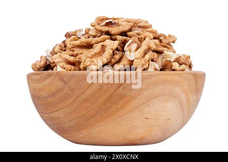 Metà del nocciolo di noce, in ciotola di legno isolata su sfondo bianco. Semi secchi e sgusciati del noce comune Juglans regia, utilizzati come snack o per Foto Stock