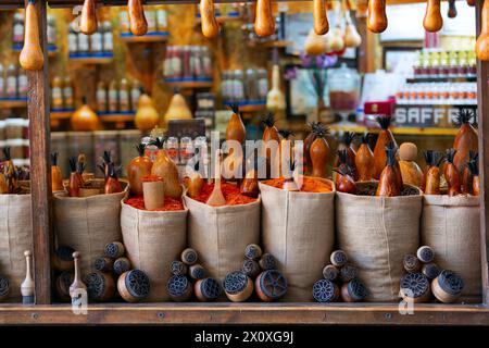 Sacchetti pieni di varie spezie multicolori e tradizionale saltshaker di legno come souvenir in una bancarella del mercato. Bukhara, Uzbekistan, Asia centrale Foto Stock