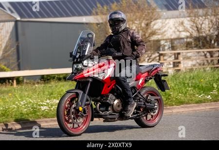 Milton Keynes, Regno Unito - 14 aprile 2024: 2023 rosso Suzuki DL 1050 rr m3 V-Strom moto che viaggia su una strada britannica Foto Stock