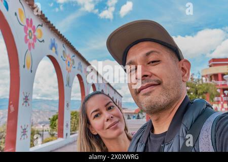 Un uomo e una donna stanno posando per una foto davanti agli archi di Acuchimay, Ayacucho. Perù Foto Stock