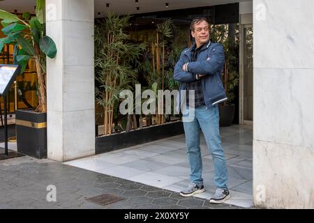 Ritratto di un uomo anziano di 50-55 anni su uno sfondo urbano neutrale, che guarda lontano. Foto Stock