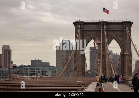 Persone che camminano sul ponte di Brooklyn, vista verso l'isola di Manhattan. Foto Stock