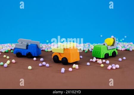 Autocarro da carico, gru e betoniera con sfondo colorato a sfere Foto Stock