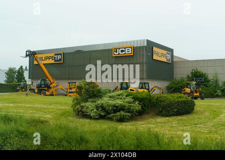 Noyelles-Godeau, Francia - 22 maggio 2023: Una flotta di macchine per l'edilizia JCB è allineata fuori dal magazzino Philippe TP, sotto un cielo nuvoloso, indica Foto Stock