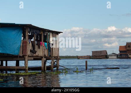 Capanne su palafitte dove il fiume Itaya incontra il Rio delle Amazzoni al di fuori di Iquitos, in Perù, nella foresta pluviale amazzonica Foto Stock