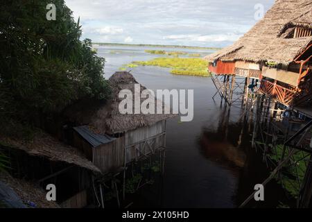 Capanne su palafitte dove il fiume Itaya incontra il Rio delle Amazzoni al di fuori di Iquitos, in Perù, nella foresta pluviale amazzonica Foto Stock