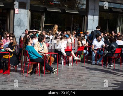 Ixelles, Bruxelles, Belgio - 13 aprile 2024 - persone sedute al sole al bar belga Queen in piazza Flagey Foto Stock