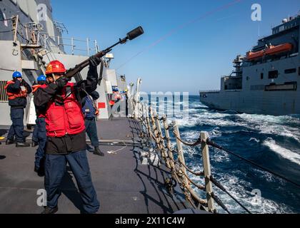 240411-N-CD453-1066 OCEANO PACIFICO SETTENTRIONALE (11 aprile 2024) Gunner's Mate 2nd Class ai'Jai Schultz, da Savannah, Georgia, spara una linea di tiro a bordo del cacciatorpediniere missilistico guidato classe Arleigh Burke USS Dewey (DDG 105) durante un rifornimento in mare con la nave cargo a secco classe Lewis e Clark USNS Cesar Chavez (T-AKE-14) mentre conduceva operazioni nel Pacifico settentrionale, 11 aprile. Dewey è schierato in avanti e assegnato al Destroyer Squadron (DESRON) 15, il più grande DESRON della Marina e la principale forza di superficie della 7a flotta statunitense. (Foto della Marina degli Stati Uniti di Samantha Oblan, specialista di comunicazione di massa di 1a classe Foto Stock