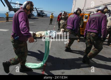 I membri dell'equipaggio della cabina di volo della Marina trasportano una vittima del terremoto haitiano nelle strutture mediche della nave d'assalto anfibia USS Bataan 21 gennaio 2010. La 22nd Marine Expeditionary Force è schierata con il Bataan Amphibious Readiness Group come parte della Unified Response al paese colpito dal terremoto di Haiti. Foto Stock