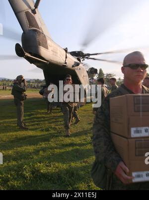 Marines con Battalion Landing Team, 3rd Battalion, 2nd Marine Regiment, 22nd Marine Expeditionary Unit, scaricamento pronto a mangiare razioni dal retro di un CH-53E Super Stallion per le vittime del terremoto a Leogane, Haiti, 20 gennaio. Il 22nd MEU è una forza multimissione composta da Aviation Combat Element, Marine Heavy Helicopter Squadron 461 (rinforzato); Logistics Combat Element, Combat Logistics Battalion 22; Ground Combat Element, BLT, 3/2; e il suo elemento di comando. (Foto ufficiale del corpo dei Marines di Lance Cpl. Christopher M. Carroll) Foto Stock