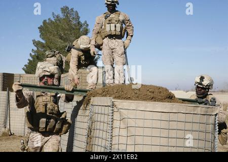 I marines con il 2nd Combat Engineer Battalion appiattiscono lo sporco di un muro protettivo su un posto di osservazione di nuova costruzione sulla rotta Cowboys, provincia di Helmand, Afghanistan, 6 gennaio 2010. Durante la loro missione sulla strada Cowboys, il 2° CEB costruì tre posti di osservazione lungo la strada. Foto Stock