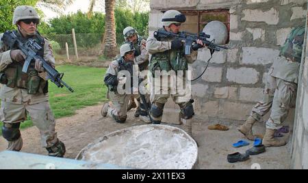 Titolo originale: I soldati della compagnia D, 1st Battalion, 8th Cavalry Regiment, si preparano ad entrare in una casa durante la ricerca del 24 aprile in un villaggio lungo il fiume Tigri CA. 24 aprile 2004 Foto Stock