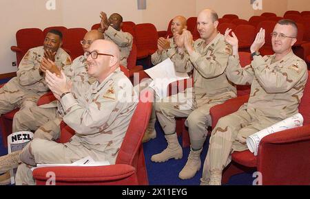 I soldati della Task Force 1st Armored Division applaudono i loro diplomati mentre assistono alla cerimonia di inizio della General H.H. Arnold High School al Kurhaus di Wiesbaden, in Germania. I soldati sono stati in grado di guardare la laurea su un sistema di videoconferenza a Freedom Rest a Baghdad, Iraq, 5 giugno 2004. Foto Stock