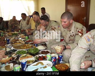 Il sergente Dave Gurba si aiuta ad alcuni dei piatti preparati dalla Liberal Faylee Kurds Organization. I soldati del 2nd Battalion, 5th Cavalry Regiment, 1st Brigade Combat Team, 1st Cavalry Division, hanno partecipato ad una cena preparata dall'Organizzazione Liberale dei curdi Faylee CA. 2004 Foto Stock