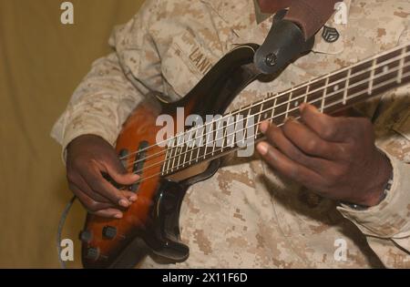 Michael Land dell'8th Engineering Battalion in Iraq suona un basso CA. 2004 Foto Stock