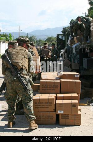 I Marines del Combat Logistics Battalion 22, 22nd Marine Expeditionary Unit accumulano razioni in un sito di distribuzione a Petit Goave, Haiti, 27 gennaio 2010. In risposta a un devastante terremoto che ha colpito il paese di Haiti, Marines e marinai della 22a MEU hanno iniziato a fornire forniture di soccorso e fornire assistenza medica a sostegno dell'operazione Unified Response, 19 gennaio. Foto Stock