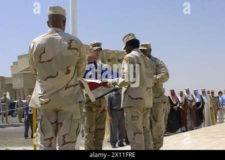 I soldati della Task Force Olympia preparano una bandiera americana da issare per aprire l'Ufficio regionale dell'Ambasciata a Camp Freedom a Mosul, Iraq, il 28 luglio 2004. All'inaugurazione parteciparono diversi leader dell'Iraq settentrionale e relatori ospiti, l'Ambasciatore degli Stati Uniti in Iraq, John Negroponte. Foto Stock