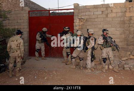 I soldati del 1st Platoon, compagnia B, 5th Battalion, 20th Infantry Regiment si spostano in una casa per cercare armi e forze anti-irachene durante le operazioni nella provincia occidentale di Ninevah, città di Tall Afar, nelle prime ore del mattino del 1 agosto 2004. Foto Stock