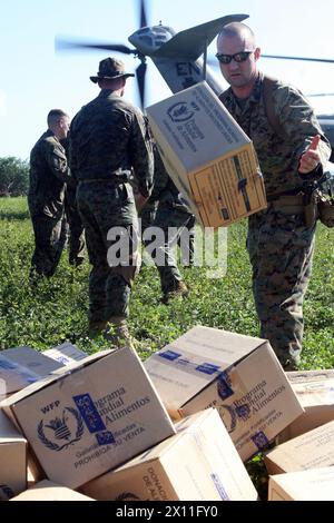 Marines della Weapons Company, Battalion Landing Team, 3rd Battalion, 2nd Marine Regiment, 22nd Marine Expeditionary Unit, scaricano un elicottero CH-53E Super Stallion dal Marine Heavy Helicopter Squadron 461 (rinforzato), riempito di barre nutrizionali e acqua a Cotes De Fer, Haiti, 21 gennaio 2010. I marines e i marinai del 22o MEU hanno istituito un punto di distribuzione temporaneo per la fornitura di aiuti nei pressi di Cotes de Fer, Haiti, portando acqua in bottiglia e cibo per gli haitiani sfollati interni. Foto Stock