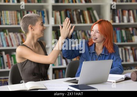 Due studenti, belle ragazze rosse e bionde che danno cinque Foto Stock