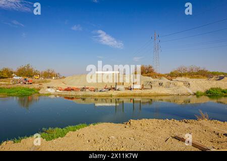 Pilastri del ponte in cemento armato in costruzione attraverso il fiume, moderna costruzione in cemento di pali che sostengono il ponte stradale. Squadra Foto Stock