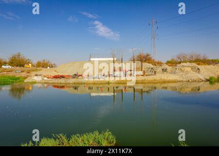 Pilastri del ponte in cemento armato in costruzione attraverso il fiume, moderna costruzione in cemento di pali che sostengono il ponte stradale. Squadra Foto Stock