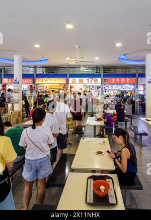 Persone in fila in un affollato Hawker Centre al mercato di Tiong Bahru nella tenuta di Tiong Bahru, Singapore Foto Stock