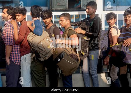 Lavoratori migranti dall'Uttar Pradesh nell'India settentrionale in coda per salire a bordo di un treno per il loro stato d'origine; al Chhatrapati Shivaji Maharaj Terminus, Mumbai, India Foto Stock