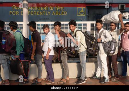 Lavoratori migranti dall'Uttar Pradesh nell'India settentrionale in coda per salire a bordo di un treno per il loro stato d'origine; al Chhatrapati Shivaji Maharaj Terminus, Mumbai, India Foto Stock