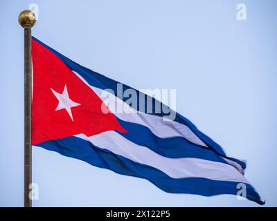 Grande bandiera nel cuore di Cuba, l'Avana. Bandiera Cuba che sventola sull'asta, vista dal basso. Bandiera di Cuba che sventola nel vento. Primo piano di una bandiera cubana che sventola nel vento su uno sfondo di cielo limpido. Foto Stock