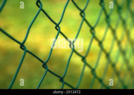 Recinzione a maglie a catena metallica verde in prospettiva, messa a fuoco selettiva Foto Stock