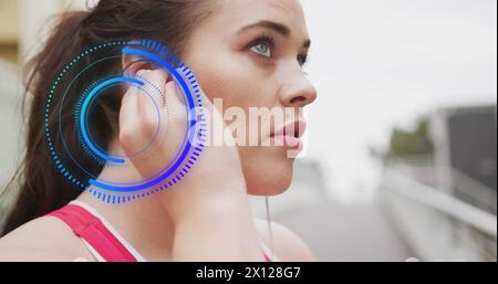 Immagine del trattamento dei dati più grande donna caucasica con auricolari che si esercitano in città Foto Stock