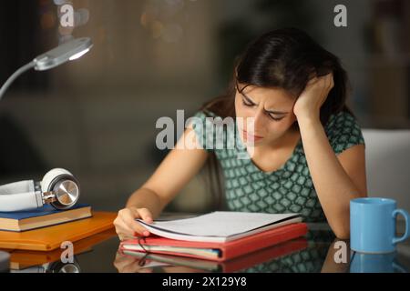 Studente frustrato durante la notte cercando di memorizzare le note a casa Foto Stock