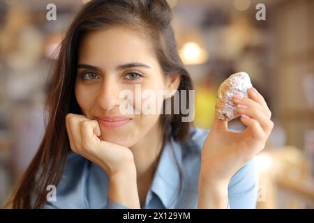 Ritratto di un cliente soddisfatto del ristorante che tiene un panificio che ti guarda Foto Stock