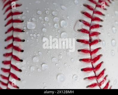 palla da baseball bianca legata con filo rosso, una vera palla da baseball rotonda in primo piano Foto Stock