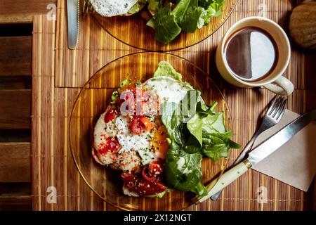 Colazione in un caffè. Tosta con uova, pomodoro e spinaci, con una tazza di caffè e un colpo di poppa Foto Stock