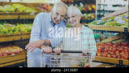 Immagine di dati finanziari e grafici sulla felice coppia senior caucasica sul mercato Foto Stock