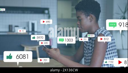 Immagine delle icone dei social media su una donna afroamericana che usa lo smartphone Foto Stock