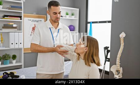 In una clinica, una paziente riceve la guida di un fisioterapista maschile durante una sessione di riabilitazione. Foto Stock